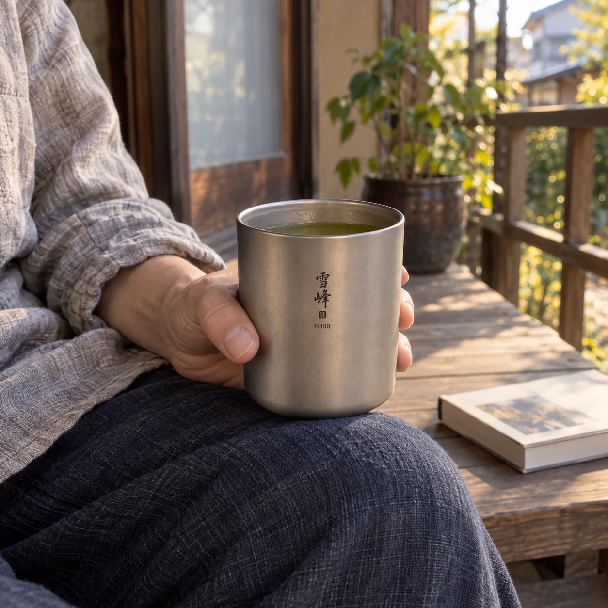 縁側で取っ手のないチタン製の雪峰H300を手に持ち、お茶を飲む場面の生成画像
